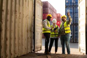 Gruppe von Arbeitskräfte im ein leeren Container Lager Hof, das Bedingung von das alt Container ist Sein beurteilt zu bestimmen ob es erfordert Instandhaltung zum Verwendung. foto