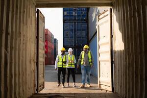 Gruppe von Arbeitskräfte im ein leeren Container Lager Hof, das Bedingung von das alt Container ist Sein beurteilt zu bestimmen ob es erfordert Instandhaltung zum Verwendung. foto