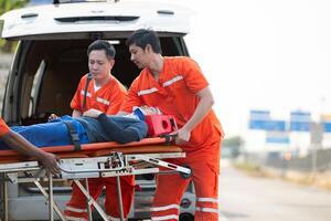 das Sanitäter ist assistieren ein verletzt Mann im ein Notfall Situation auf das Straße. foto