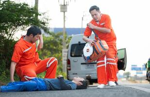 das Sanitäter ist assistieren ein verletzt Mann im ein Notfall Situation auf das Straße. foto