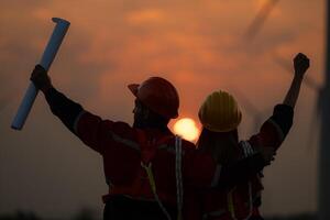 Silhouette von Ingenieur und Techniker mit ein Wind Bauernhof und Sonnenuntergang Hintergrund foto