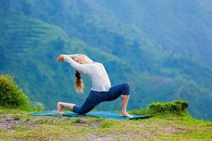 sportlich passen Frau Praktiken Methoden Ausübungen Yoga Asana anjaneyasana im Berge foto