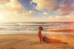 Frau Praktiken Methoden Ausübungen Yoga Asana urdhva Mukha svanasana beim das Strand foto