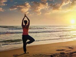 jung sportlich passen Frau tun Yoga Baum Asana auf Strand foto