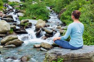 Frau im Padmasana draußen foto