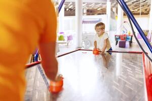 Junge spielen Luft Eishockey im Innen- abspielen Bereich. foto