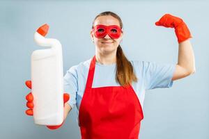 Frau im rot Maske, Gummi Handschuhe und Schürze halten Reinigung Agent Flasche foto