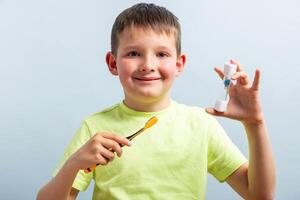 Kind Junge mit Sanduhr Bürsten seine Zähne auf Blau Hintergrund foto