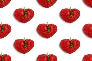 hässlich Erdbeere im das gestalten von ein Herz auf s Weiß Hintergrund. nahtlos Muster. lustig, hässlich Gemüse. foto