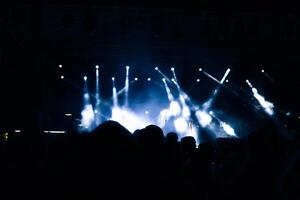 Scheinwerfer auf das Bühne. Silhouette von Menschen im ein Konzert. foto