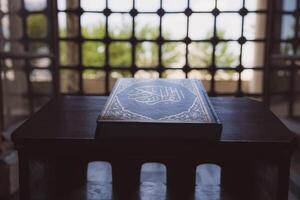 islamisch oder Ramadan Hintergrund Foto. das heilig Koran auf das Buch Stand foto