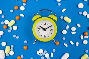 medizinisch Tabletten mit Alarm Uhr. nehmen Tabletten oder Kapseln auf Zeit Konzept Foto