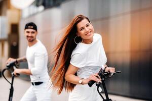 ein Mädchen und ein Kerl sind Gehen auf elektrisch Roller um das Stadt, ein Paar im Liebe auf Roller. foto