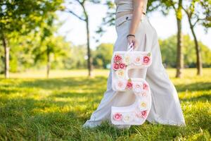 schön Frau mit Papier Nummer mit Blumen im Hand - - Dekorationen gemacht mit Ihre besitzen Hände. klein Geschäft Konzept. foto