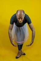komisch Porträt von männlich Ballett Tänzer. ein reifen Ballett Tänzer gekleidet im Tutu Tanzen ungeschickt foto