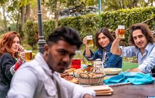 Gruppe von multikulturell freunde haben Spaß beim Garten Party - - jung Menschen lächelnd zusammen Essen Essen und Trinken Bier foto