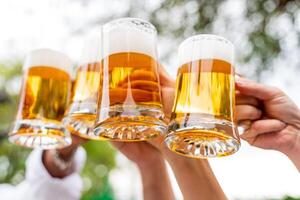 Gruppe von Menschen genießen und Toasten ein Bier draußen - - Nahansicht auf vier Pint von Bier foto