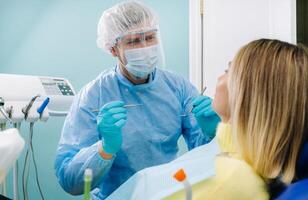 das geduldig lächelt im das Zahnarzt Stuhl im ein schützend Maske und Instrument Vor Behandlung im das Dental Büro foto