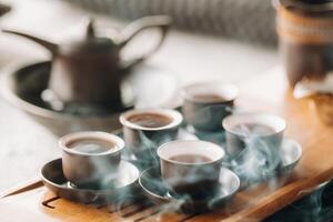 Tassen mit gegossen Tee Vor das Tee Zeremonie mit Weihrauch foto