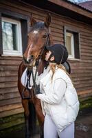 schön blond Fachmann weiblich Jockey im Weiß Kleider küssen Pferd. Freundschaft mit Pferd foto