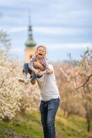 Vater und Tochter haben ein Spaß zusammen unter ein Blühen Baum im Frühling Park petrin im Prag, Europa foto