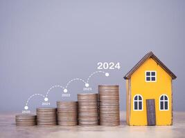 Miniatur Haus und Stapel von Münzen mit Graph. das Konzept Über Preis von Haus ist wachsend hoch, Eigentum Investition, Haus Hypothek, echt Nachlass im Jahr 2024 foto