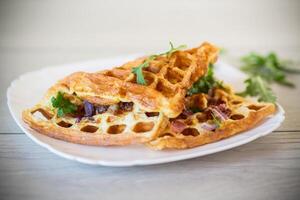 Ei Omelette ausgestopft mit Zwiebeln und Kräuter, gebraten im das bilden von Waffeln foto