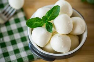 klein Bälle von traditionell Mozzarella im ein Keramik Schüssel foto