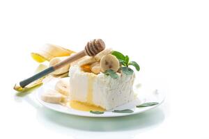 Portion von hausgemacht Milch Quark mit Banane Scheiben und Honig foto