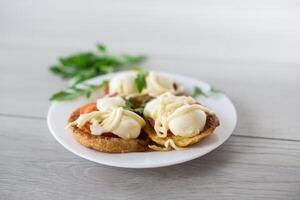 gebraten im Teig Sandwiches mit Tomaten und Mozzarella im ein Teller mit Kräuter foto