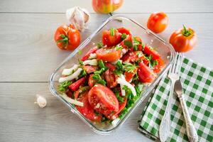 würzig Snack Tomaten mit Knoblauch, Kräuter, Gewürze und Zwiebeln im ein Glas Schüssel . foto