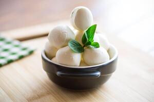 klein Bälle von traditionell Mozzarella im ein Keramik Schüssel foto