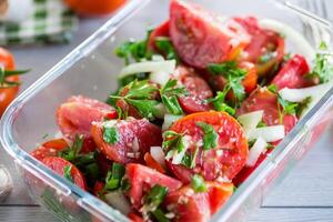 würzig Snack Tomaten mit Knoblauch, Kräuter, Gewürze und Zwiebeln im ein Glas Schüssel . foto