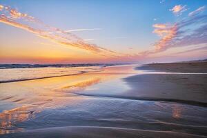 atlantisch Ozean Sonnenuntergang mit wogend Wellen beim fonte da telha Strand, Portugal foto