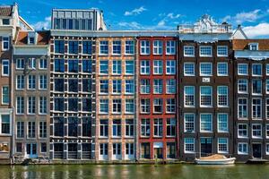 Häuser und Boot auf Amsterdam Kanal damrak mit Betrachtung. ams foto