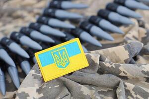 ukrainisch Symbol und ein Maschine Gewehr Gürtel auf das tarnen Uniform von ein ukrainisch Soldat. das Konzept von Krieg im Ukraine, Patriotismus und schützen Ihre Land von Besatzer foto
