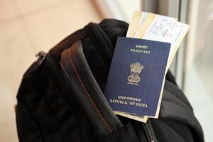 Blau indisch Reisepass mit Fluggesellschaft Tickets auf touristisch Rucksack foto