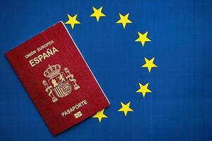 rot Spanisch Reisepass von europäisch Union auf Blau Flagge Hintergrund schließen oben foto