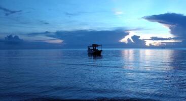 Fischerboot im Meer bei Sonnenuntergang foto
