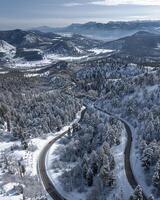 ai generiert Antenne Aussicht von Wicklung Straße im Berge mit Schnee foto