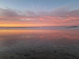 Sonnenuntergang beim playa de Famara, Lanzarote, Farben das Himmel mit beschwingt Farbtöne, Gießen ein faszinierend glühen Über das Horizont. atemberaubend Sicht Das erfasst das Wesen von Ruhe und natürlich Schönheit. foto