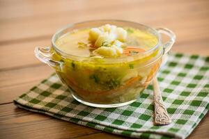 gekocht Hähnchen Suppe mit Blumenkohl und Gemüse im ein Schüssel foto