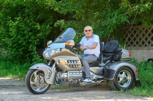 Alten Mann Sitzung auf ein Motorrad 2 foto