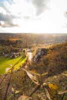 felsig Umgebung in der Nähe von das Stadt, Dorf von dinant mit ein Wasserlauf Das Formen natürlich schlängelt sich im Herbst Farbe. das Sonnenuntergang leuchtet ein bunt Wald foto