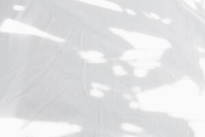 Schatten Blätter Overlay auf Weiß Baumwolle Bett Blatt, natur Sonnenlicht leuchtenden durch Fenster auf abstrakt Weiß Stoff Textur Hintergrund. Stoff Sanft Welle Bettwäsche auf gemütlich Bett im Sommer- foto