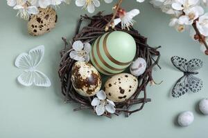 Ostern Eier im das Nest mit Blumen und Schmetterling auf Pastell- Grün Hintergrund foto