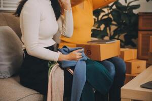 asiatische KMU-Geschäftsfrauen verwenden Laptop-Computer, um die Online-Versandkartons der Kundenbestellung zu Hause zu überprüfen. Kleines Unternehmen starten Unternehmer KMU freiberuflich. online-geschäft, konzept für die arbeit zu hause. foto