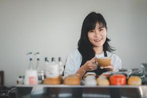 lächeln schön Frau Barista Hand halten Tasse von Kaffee zum Kunde im Kaffee Geschäft. foto