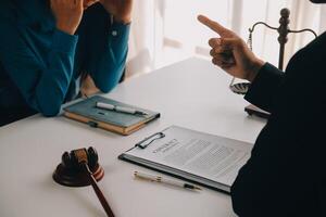 Gerechtigkeits- und Rechtskonzept. Legal Counsel präsentiert dem Mandanten einen unterschriebenen Vertrag mit Hammer und Legal Law oder Legal mit Teammeeting in der Anwaltskanzlei im Hintergrund foto