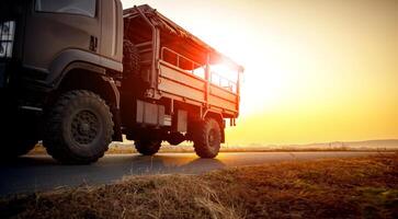 Militär- LKW Laufen auf Asphalt Autobahn gegen schön Sonnenuntergang Himmel foto